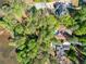 Aerial view highlighting the home's location surrounded by mature trees with lake access at 9355 Huntcliff Trce, Sandy Springs, GA 30350