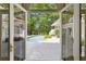 View from inside the home to the refreshing backyard pool, patio and lush green landscaping at 9355 Huntcliff Trce, Sandy Springs, GA 30350