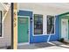 Close-up of a modern townhome exterior featuring a green door, black-framed windows, and blue siding at 1095 Tucker Ave # 503, Atlanta, GA 30310