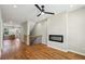 Inviting living area features hardwood floors, a modern fireplace, ceiling fan, and view of the staircase at 1095 Tucker Ave # 503, Atlanta, GA 30310