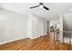 Open-concept living room with hardwood floors, access to the kitchen, and staircase with black railings at 1095 Tucker Ave # 503, Atlanta, GA 30310