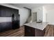 Modern kitchen with dark cabinets, stainless steel appliances, and center granite island at 1800 Forkview Ct, Lawrenceville, GA 30044