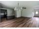 Expansive living room with wood floors, chandelier, and seamless flow to the kitchen at 1800 Forkview Ct, Lawrenceville, GA 30044