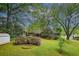 Expansive backyard featuring lush lawn, mature trees, brick patio, and a storage shed at 3501 Montreal Way, Tucker, GA 30084