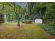 Private backyard with lush lawn, mature trees, and a garden shed, perfect for relaxation at 3501 Montreal Way, Tucker, GA 30084