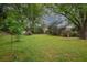 Large grassy backyard offers plenty of space for outdoor activities, framed by mature trees at 3501 Montreal Way, Tucker, GA 30084
