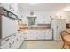 Bright eat-in kitchen features white cabinetry, vintage appliances, laminate counters, and patterned flooring at 3501 Montreal Way, Tucker, GA 30084