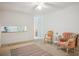 Bonus room with two chairs, side table, area rug, and peek into kitchen at 3501 Montreal Way, Tucker, GA 30084