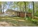 Back exterior view of the home with covered parking and lush greenery, framed by mature trees at 618 Buchanan Hwy, Dallas, GA 30157