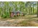 A quaint brick house framed by lush trees, showcasing a peaceful and private outdoor setting at 618 Buchanan Hwy, Dallas, GA 30157