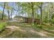 Exterior view of the home with a covered driveway and a lush, well-manicured lawn and mature trees at 618 Buchanan Hwy, Dallas, GA 30157