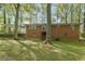 Rear view of the brick home with covered patio, nestled in a lush, green yard with mature trees at 618 Buchanan Hwy, Dallas, GA 30157