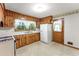 The kitchen offers knotty pine cabinetry, a white countertop and white refrigerator at 618 Buchanan Hwy, Dallas, GA 30157
