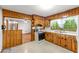 The kitchen features knotty pine cabinetry, a white countertop and white appliances at 618 Buchanan Hwy, Dallas, GA 30157