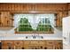 The kitchen includes knotty pine cabinetry with a double stainless steel sink and a wooded view at 618 Buchanan Hwy, Dallas, GA 30157