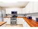 Well-equipped kitchen featuring white cabinets, stainless steel appliances, and butcher block countertops at 7840 Highway 101, Rockmart, GA 30153