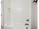 White tiled shower and bathtub showcasing black fixtures and a built-in niche at 1095 Tucker Ave # 408, Atlanta, GA 30310