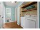 Practical laundry area with a washer, dryer, and built-in shelving for storage at 1925 Commonwealth Ct, Cumming, GA 30041