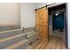View of basement area with storage bench and sliding wooden door with access to exercise room at 225 Nacoochee Dr, Woodstock, GA 30188