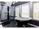 Bathroom featuring a modern shower and a freestanding tub with claw feet, complemented by ample natural light at 225 Nacoochee Dr, Woodstock, GA 30188