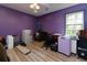 Bedroom with purple walls and modern wood flooring, large window, and lots of storage at 225 Nacoochee Dr, Woodstock, GA 30188