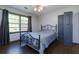 This bedroom features a decorative metal bed frame, ceiling fan, and large window at 225 Nacoochee Dr, Woodstock, GA 30188