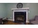 Close-up of a marble-surround fireplace, complemented by hardwood floors at 225 Nacoochee Dr, Woodstock, GA 30188