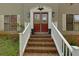 Inviting front entrance with brick steps, white railings, and a decorative red double-door at 225 Nacoochee Dr, Woodstock, GA 30188