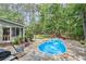 Landscaped backyard featuring a kidney shaped pool, stone patio, and outdoor seating at 24 Picketts Mill Pl, Acworth, GA 30101