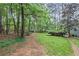 Spacious backyard featuring mature trees, and lush lawn extending into the woods at 24 Picketts Mill Pl, Acworth, GA 30101