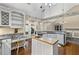 Gourmet kitchen with an island cooktop, granite counters, white cabinets, and access to the porch at 24 Picketts Mill Pl, Acworth, GA 30101