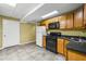 Kitchen with tile floors, wood cabinets, black appliances, and yellow walls at 24 Picketts Mill Pl, Acworth, GA 30101