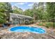 Backyard features a refreshing pool area with a stone patio, grill, and fenced yard at 24 Picketts Mill Pl, Acworth, GA 30101