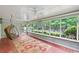Bright sunroom with many windows, ceiling fans, and a swinging chair to enjoy a relaxing view of nature at 24 Picketts Mill Pl, Acworth, GA 30101