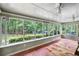 Bright sunroom with many windows, ceiling fans, and a view of the landscaped backyard at 24 Picketts Mill Pl, Acworth, GA 30101