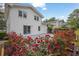 A view of the home's backyard featuring manicured flowerbeds, concrete patio, white painted brick, and mature trees at 3182 Wakefield Dr, Decatur, GA 30034