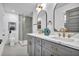 Elegant bathroom boasts double vanity with marble countertop, grey cabinetry, and glass shower enclosure with marble-style accent wall at 3182 Wakefield Dr, Decatur, GA 30034
