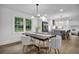 The dining room features a dark table with white chairs, a modern light fixture, and views of the kitchen at 3182 Wakefield Dr, Decatur, GA 30034