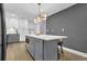 This open kitchen features a center island with seating, modern light fixtures, and gray cabinets at 3182 Wakefield Dr, Decatur, GA 30034