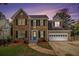 Charming two-story brick home boasts a manicured lawn, attached two car garage, and inviting curb appeal at 651 Deer Oaks Dr, Lawrenceville, GA 30044