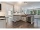 Well-lit kitchen boasts stainless steel appliances, granite countertops, white cabinets, and hardwood floors at 651 Deer Oaks Dr, Lawrenceville, GA 30044