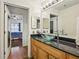 Tastefully decorated bathroom with a wood vanity, granite countertop, glass bowl sink, and tile floor at 800 Peachtree Ne St # 2304, Atlanta, GA 30308