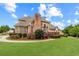 The beautifully landscaped backyard showcases vibrant flowers, a wooden deck, and mature trees at 1364 Gulfport Run, Grayson, GA 30017