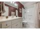 Bathroom with red wallpaper, a white vanity, and combination shower and tub at 1364 Gulfport Run, Grayson, GA 30017