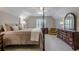 Bedroom featuring neutral carpet, natural light, stylish wooden furniture, and green chair at 1364 Gulfport Run, Grayson, GA 30017