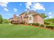 Rear exterior view showing brick architecture, large windows, wooden deck, and well-manicured lawn at 1364 Gulfport Run, Grayson, GA 30017