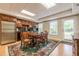 A basement kitchen featuring light wooden cabinets, a refrigerator, a microwave, a stove, and a dining table at 1364 Gulfport Run, Grayson, GA 30017