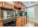 Convenient kitchenette with stainless steel appliances, dark granite countertops, and wood cabinets at 1364 Gulfport Run, Grayson, GA 30017
