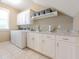 Laundry room with white cabinets, granite countertops, and tile flooring at 1364 Gulfport Run, Grayson, GA 30017