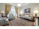 Cozy living room showcasing large windows, elegant furniture, and a decorative rug on wood floors at 1364 Gulfport Run, Grayson, GA 30017